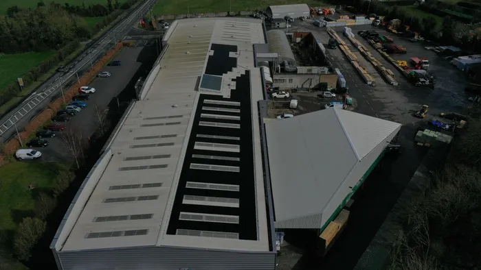 Commercial solar panel array installed across a large industrial roof in Ireland